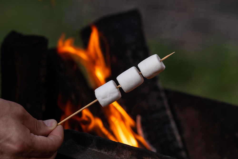 A homeowner cooks some marshmallows following fire pit and outdoor fireplace design in Overland Park